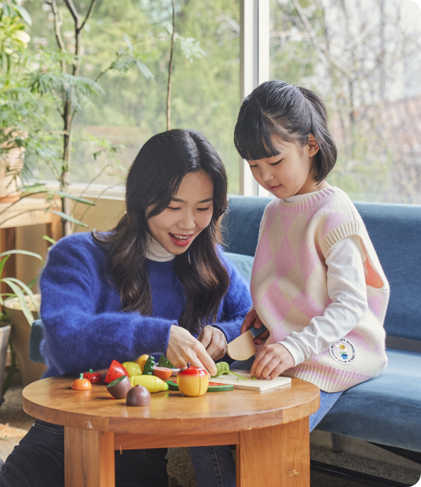 어린 아이와 어머니가 함께 소꿉놀이 하고 있는 모습